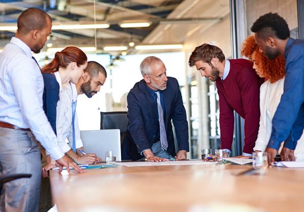 team looking over documents at table in office